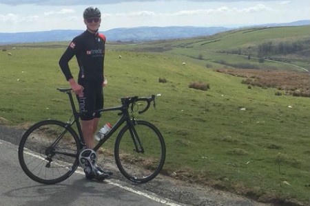 Ieuan on his bike posing for a landscape photo in the Welsh mountains